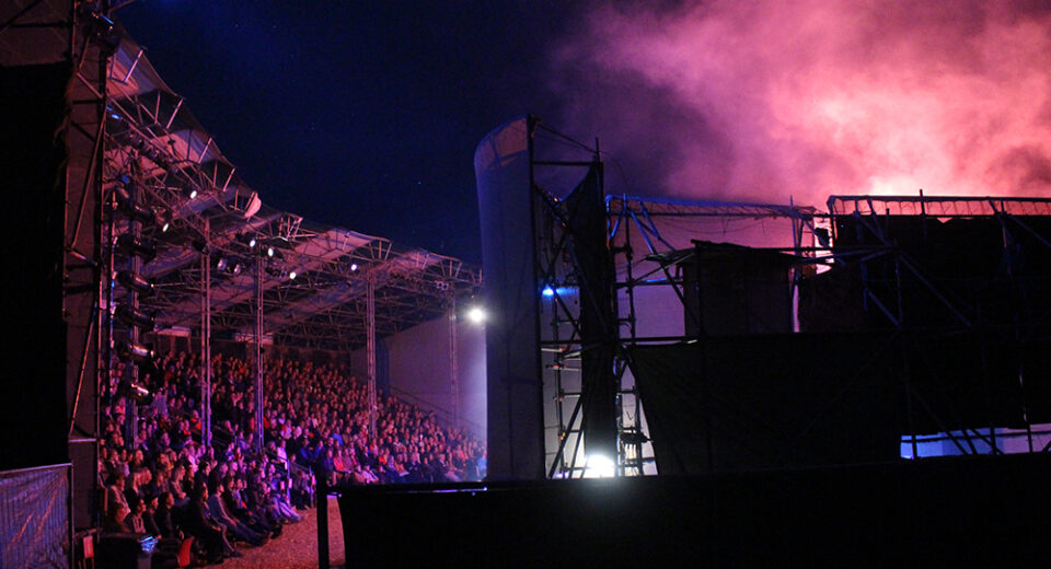 Theatergezelschap Vis à Vis - Copyright Kimberley Vonk (9)_low res Foto van de tribune (links) en de achterzijde van het toneel (rechts). Er is een rookwolk vanaf het podium.